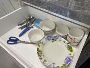 a white counter with a plate and bowls and scissors at Sandakan Homestay Coastal Serenity 山海绿栖 in Sandakan