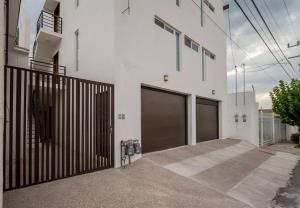 un edificio bianco con due porte del garage di Barcelona Loft a Chihuahua