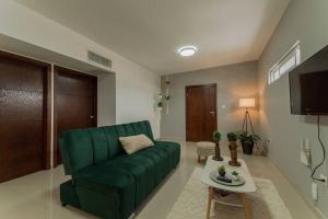 un soggiorno con divano verde e tavolo di Barcelona Loft a Chihuahua