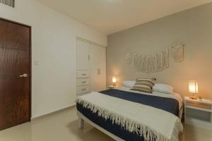 1 dormitorio con 1 cama grande y 2 lámparas en Barcelona Loft, en Chihuahua