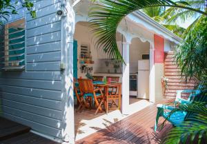 un patio con tavolo e sedie su un ponte di Bungalow La Papaye Bleue Résidence accès Piscine & Plage a Saint-François