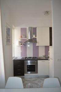 a kitchen with white cabinets and a stove top oven at Casa Elena in Maiori