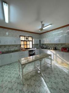 a large kitchen with a table in the middle at Alsalam Farmhouse in Hatta