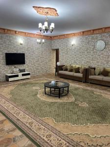 a living room with a couch and a table at Alsalam Farmhouse in Hatta