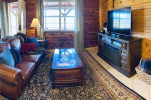 a living room with a couch and a flat screen tv at The Presidential Barndominium in the Stable at Bear Mountain in Eureka Springs