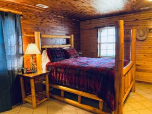 um quarto com uma cama num chalé de madeira em The Presidential Barndominium in the Stable at Bear Mountain em Eureka Springs