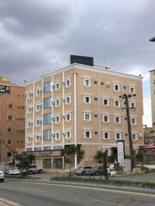 a large apartment building on the side of a street at فندق وشقق ليالي الاحلام للشقق المخدومه in Baljurashi