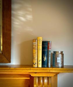 4 libros sentados en un estante de madera en The Glebe Cottage, en Hobart