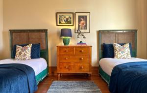 1 dormitorio con 2 camas y vestidor con lámpara en The Glebe Cottage, en Hobart