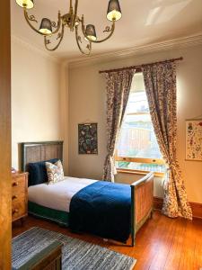 1 dormitorio con cama y ventana en The Glebe Cottage, en Hobart