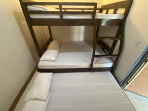 Teo’s Spacious and Affordable Home in Cabanatuan في كاباناتوان: غرفة صغيرة بها سريرين بطابقين