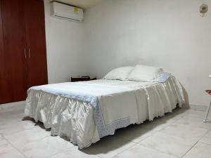 a bedroom with a bed with a white blanket on it at Casa Encanto Cartagena Colombia in Cartagena de Indias