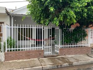 una recinzione bianca di fronte a una casa di Casa Encanto Cartagena Colombia a Cartagena de Indias