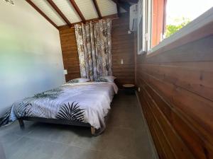 a small bed in a room with a window at Charmante Villa, kaz’ AA.Liyah in Pointe-à-Pitre