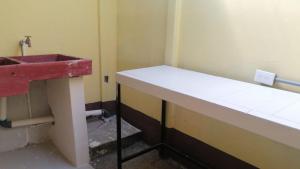 La salle de bains est pourvue d'un lavabo rouge et d'un comptoir. dans l'établissement Cabinas Lawson, à Puerto Jiménez