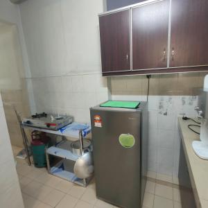 a kitchen with a stainless steel refrigerator and wooden cabinets at Fayyadh Homestay Selayang - 3 Bilik 2 Bilik Air -malay only in Batu Caves