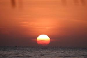 a sunset over the ocean with the sun in the sky at Full Moon Village Resort in Mui Ne
