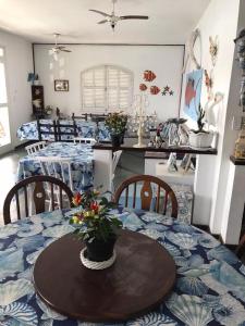a dining room with a table and chairs with a table and a dining room at Pousada Recanto Marinho in Arraial do Cabo