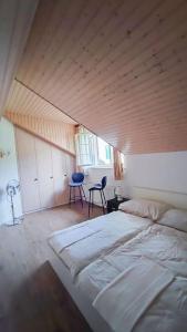 een slaapkamer met een groot bed en een houten plafond bij Duplex avec vue lac et montagnes in Montreux