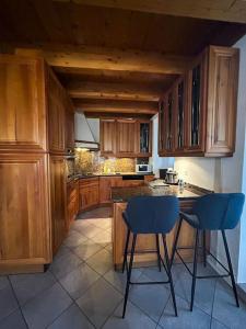 una cucina con armadi in legno e sedie blu di Duplex avec vue lac et montagnes a Montreux