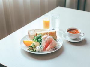 uma mesa branca com um prato de comida e uma chávena de café em Hamilton Hotel Red em Nagoia