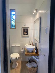ein Bad mit einem Waschbecken, einem WC und einem Fenster in der Unterkunft Rincón Colonial in Colonia del Sacramento