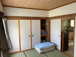 mały pokój z łóżkiem i szafą w obiekcie Furano Rental House w mieście Furano