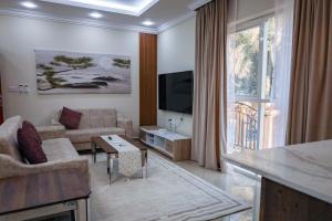 ein Wohnzimmer mit einem Sofa und einem TV in der Unterkunft Hatta Orchard in Hatta