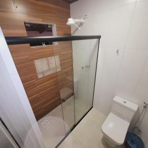 uma casa de banho com um WC e uma cabina de duche em vidro. em Hilton Hotel em Barra do Garças