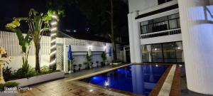 a swimming pool in front of a building at night at Villa Samnang BOUTIQUE HOTEL in Phnom Penh