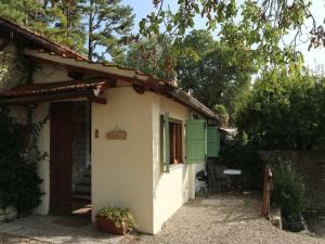 una piccola casa bianca con una porta verde di Belvilla by OYO Noce a Donnini