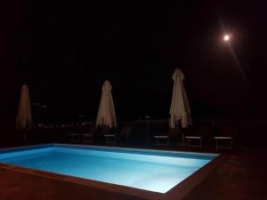 ドンニーニにあるModern Holiday Home in Pelago with Poolの夜間のスイミングプール(パラソル付)