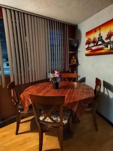 comedor con mesa de madera y sillas en Departamento de huéspedes Grijalva, en Ciudad de México