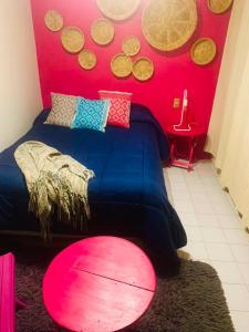 Un dormitorio con una cama azul y una pared roja con monedas. en DEPARTAMENTO EN SAN CRISTOBAL Centro ESTACIONAMIENTO LUGARES PUBLICOS EN LA CALLE, en San Cristóbal de Las Casas