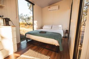 a small bedroom with a bed and a large window at Ridgeway Retreat in Queanbeyan