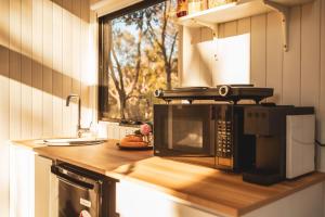 a kitchen with a counter with a microwave and a window at Ridgeway Retreat in Queanbeyan