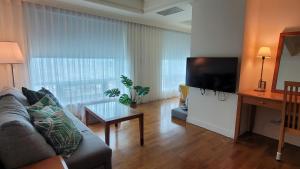 a living room with a couch and a flat screen tv at Corner Inn in Taichung