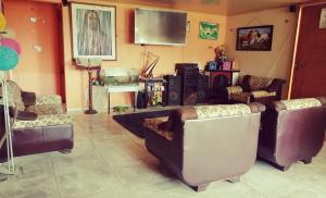 a living room with couches and a flat screen tv at Hospedaje Rural Villa Sadais in Monguí