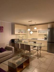 a kitchen and living room with a table and a couch at vacaciones con laguna in Algarrobo
