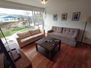 a living room with a couch and a coffee table at Departamento Ribera del Pipo in Ushuaia