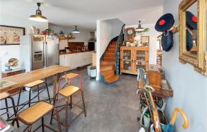 eine Küche mit einem Tisch, Stühlen und einem Kühlschrank in der Unterkunft 4 Bedroom Stunning Home In Margerie-chantagret in Soleymieux