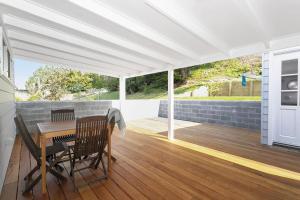 a patio with a table and chairs on a deck at Pas Beach House Apartment 2 in Mollymook