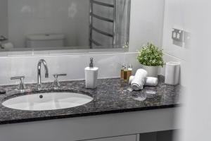 Un mostrador de baño con un lavabo y un espejo. en Aqua Shores Apartment, en Mollymook 19 fotos más