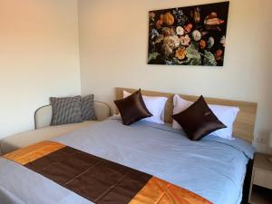 a bed in a bedroom with a painting on the wall at La Habana Hua Hin in Hua Hin