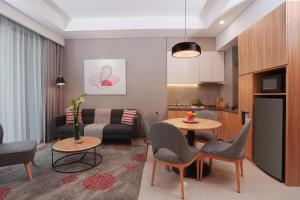 a living room with a couch and a table and chairs at Citadines Gatot Subroto Jakarta in Jakarta