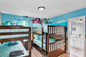 1 Schlafzimmer mit 2 Etagenbetten mit einer blauen Wand in der Unterkunft Magical Retreat in Kissimmee