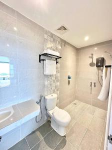 a bathroom with a toilet and a tub and a sink at Coastal Bay Staycation in Dungun