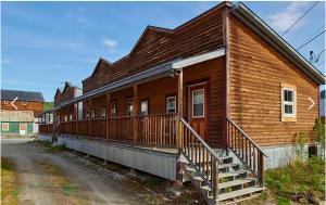 ein Holzhaus mit einer Veranda auf einer Straße in der Unterkunft Klondike Kate's Cabins in Dawson City