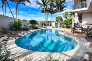 einen Pool im Hinterhof mit Palmen in der Unterkunft Maroochydore Stylish Luxury - Pool / Beach ZD9 in Maroochydore