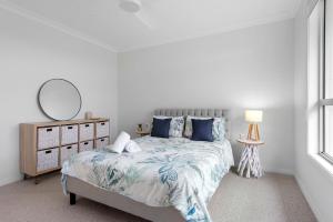 a bedroom with a bed with a mirror and a dresser at Iluka Coastal Retreat in Narrawallee
